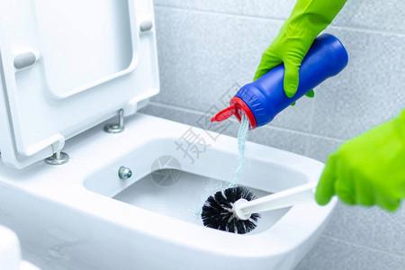 戴橡胶手套的女佣使用清洁产品和刷子清洗和消毒厕所家图片